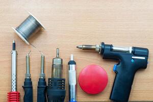 Essential electronics soldering and desoldering tools arranged on a workbench photo