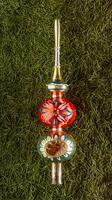 The top of the tree is the crown. Christmas tree toy with green needles in the background photo