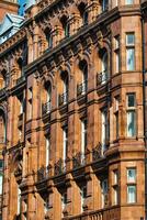 Brown Stone Building Facade with Arched Windows and Balconies in Manchester, UK. photo