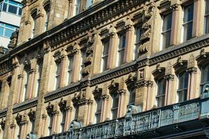 Building Facade with Windows, Ornate Details, and Balcony in Manchester, UK. photo