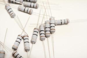 Porcelain resistors displayed against a neutral white surface. Electrical components utilized in tech devices. photo