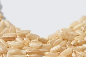 Close up of uncooked jasmine rice grains on white background with text space. photo