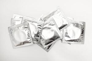 Sparkling prophylactic wrappers on a white base. photo