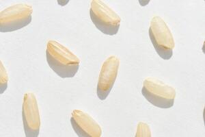 Close up of raw white rice grains on white background showcasing texture and light. photo