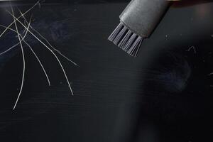 Cleaning computer screen with brush and removing dust and hair for maintenance. photo