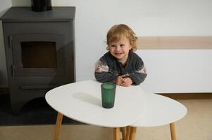 Smiling Child in Cozy Room by a Potbelly Stove for Warmth photo