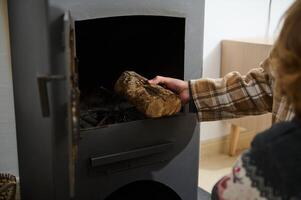 Adding a Log to a Potbelly Stove in a Cozy Home Setting photo