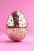 A shiny ball with multicolored glitter on a pink background photo