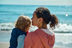 Mother and Child Enjoying Beachfront Scenery During a Serene Summer Day photo
