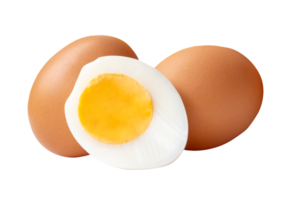Two raw brown chicken eggs and cooked or boiled chicken egg with egg yolk in half in small pile isolated with clipping path in file format png