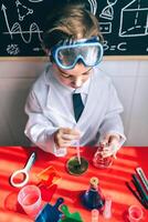 A young boy in a lab coat and goggles is working on a project. photo