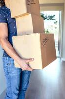 A man carrying a stack of boxes in his hand photo