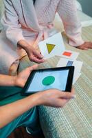 A woman in a robe is playing with a tablet photo