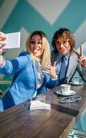 Two people in business attire taking a selfie photo