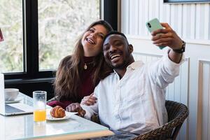 A man and woman taking a selfie in front of a window photo