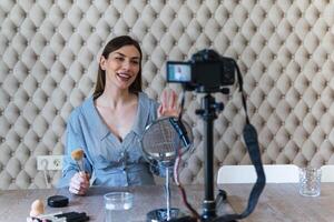 A woman is sitting at a table with a camera and a microphone photo