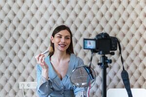 A woman is holding a camera and smiling photo