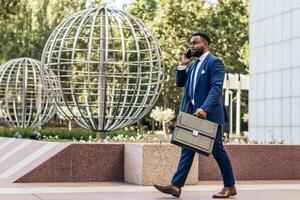 A man in a suit and tie walking with a briefcase photo