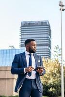 A man in a suit and tie is standing in front of a building photo