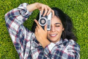 A woman is taking a picture with an old camera photo
