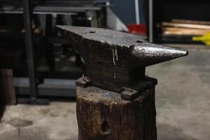 A blacksmith's anvil on a wooden post. photo