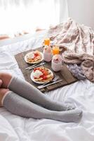 A woman in a bed with a tray of food photo