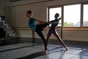 Two dancers in a dance studio with the sun shining on them photo