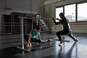 Two people in a dance studio practicing on a bar photo