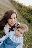 A woman and her child are sitting in the grass photo