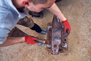 A man is using a hammer to make a piece of metal photo