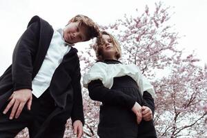 Two young people standing in front of a tree photo