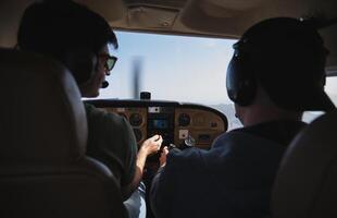 Two men in the cockpit of a small plane photo