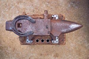 A rusty metal object with a horseshoe on it photo
