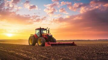 A tractor diligently plows through a vast field as the sun sets, casting warm hues across the sky filled with vibrant clouds on this lovely evening photo