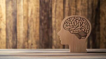 Wooden brain sculpture designed to represent cognitive processes located on a rustic table against a textured wooden backdrop photo