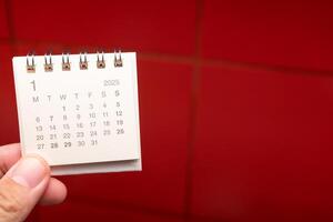 Desk Calendar for JANUARY 2025 background. Calendar concept with 2025 JAN calendar on red background. photo