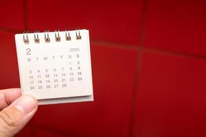 Desk Calendar for FEBRUARY 2025 background. Calendar concept with 2025 FEB calendar on red background. photo