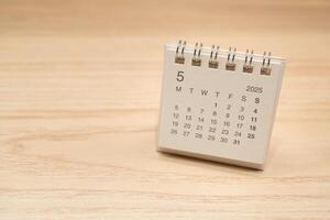 Desk Calendar for MAY 2025 background. Calendar concept with 2025 MAY calendar on wooden background. Copy Space for text. photo