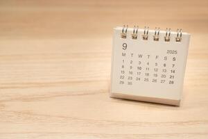 Desk Calendar for SEPTEMBER 2025 background. Calendar concept with 2025 SEP calendar on wooden background. Copy Space for text. photo