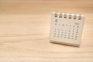 Desk Calendar for AUGUST 2025 background. Calendar concept with 2025 AUG calendar on wooden background. Copy Space for text. photo
