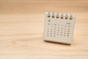 Desk Calendar for APRIL 2025 background. Calendar concept with 2025 APR calendar on wooden background. Copy Space for text. photo