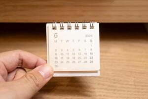 Desk Calendar for JUNE 2025 background. Calendar concept with 2025 JUN calendar on wooden background. photo