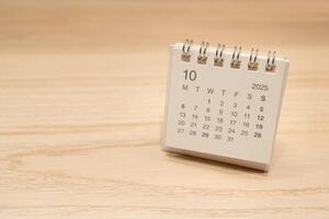 Desk Calendar for OCTOBER 2025 background. Calendar concept with 2025 OCT calendar on wooden background. Copy Space for text. photo