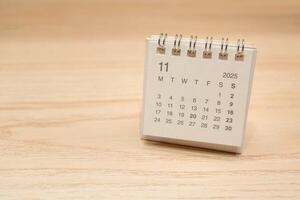 Desk Calendar for NOVEMBER 2025 background. Calendar concept with 2025 NOV calendar on wooden background. Copy Space for text. photo