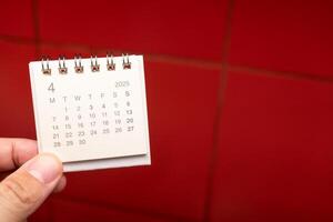 Desk Calendar for APRIL 2025 background. Calendar concept with 2025 APR calendar on red background. photo
