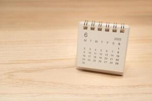Desk Calendar for JUNE 2025 background. Calendar concept with 2025 JUN calendar on wooden background. Copy Space for text. photo