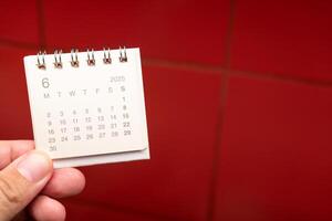 Desk Calendar for JUNE 2025 background. Calendar concept with 2025 JUN calendar on red background. photo