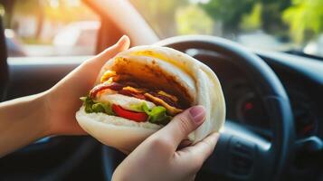 Delicious sandwich held by a driver in a car during golden hour, showcasing a juicy filling and fresh ingredients photo