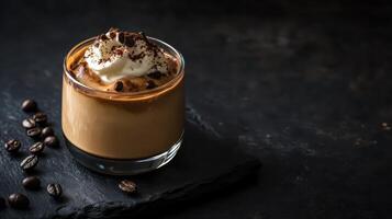 Indulge in a delightful creamy coffee dessert, lavishly adorned with a generous layer of whipped cream and sprinkled with rich chocolate, all elegantly displayed on a sophisticated dark slate surface photo