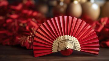 A red fan is on a wooden table photo